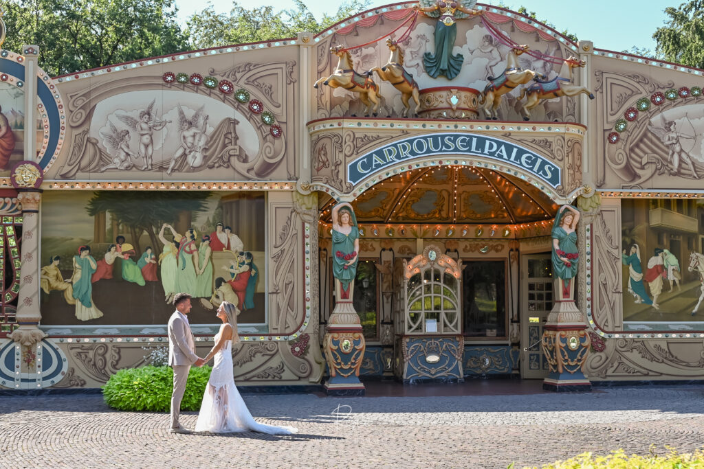 Bruidspaar voor een kleurrijke carrousel tijdens een trouwreportage
