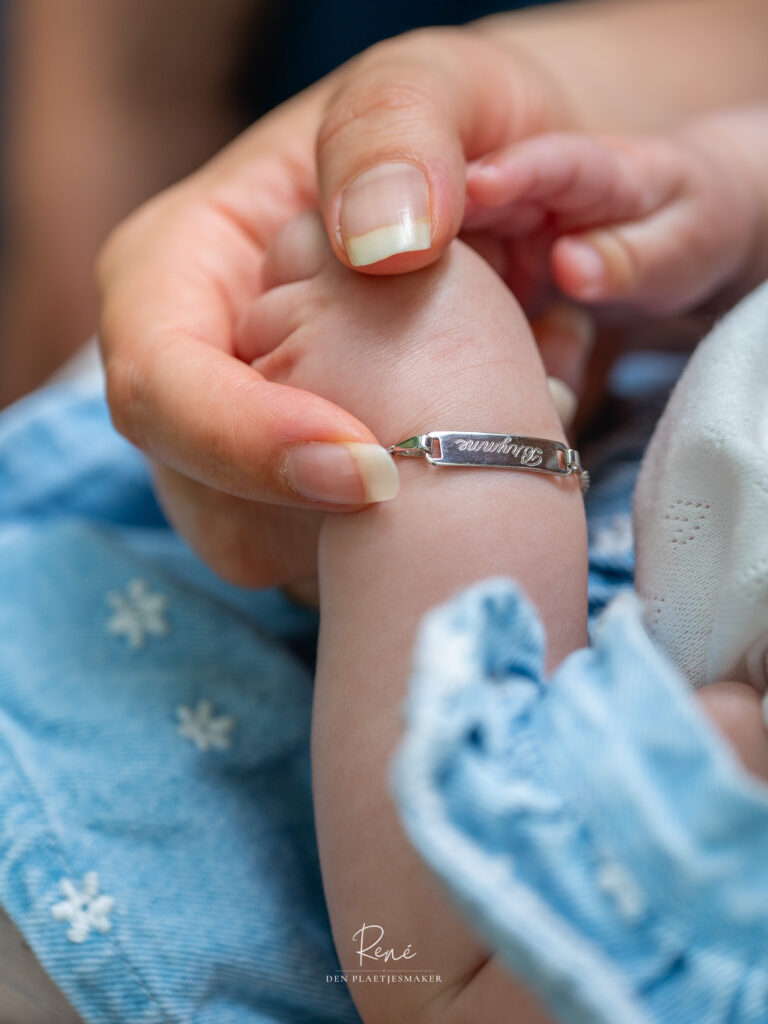 Close-up van een kinderhand met een armbandje tijdens een familieshoot