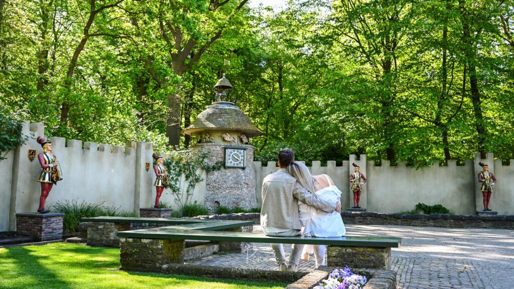 Stel zit samen in een groene omgeving tijdens een romantische fotoshoot
