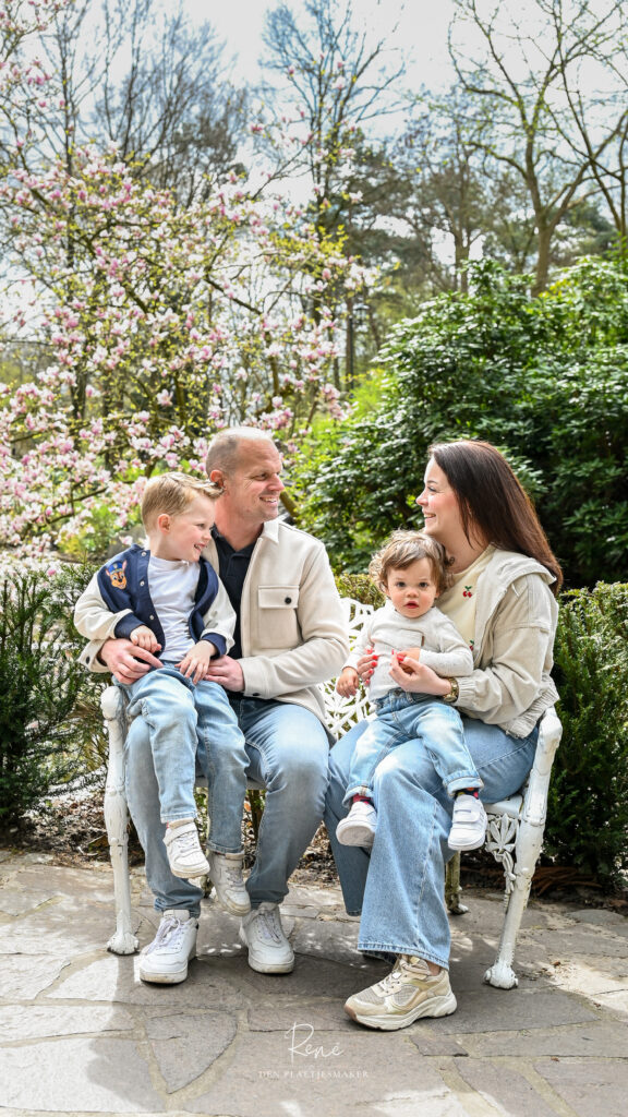 Gezin met twee kinderen zit samen buiten tijdens een ontspannen familieshoot