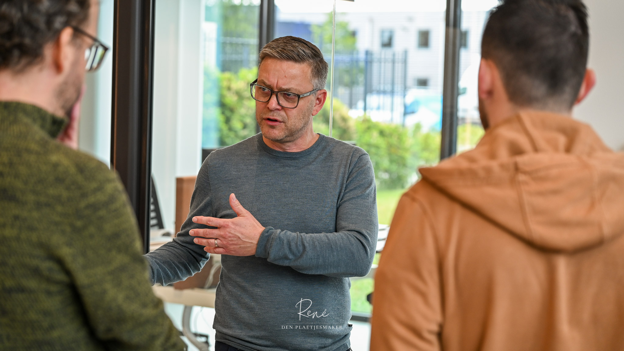 Man geeft uitleg aan bezoekers tijdens een zakelijke bijeenkomst