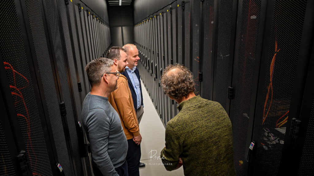 Bezoekers bekijken serverracks tijdens een rondleiding door een datacenter