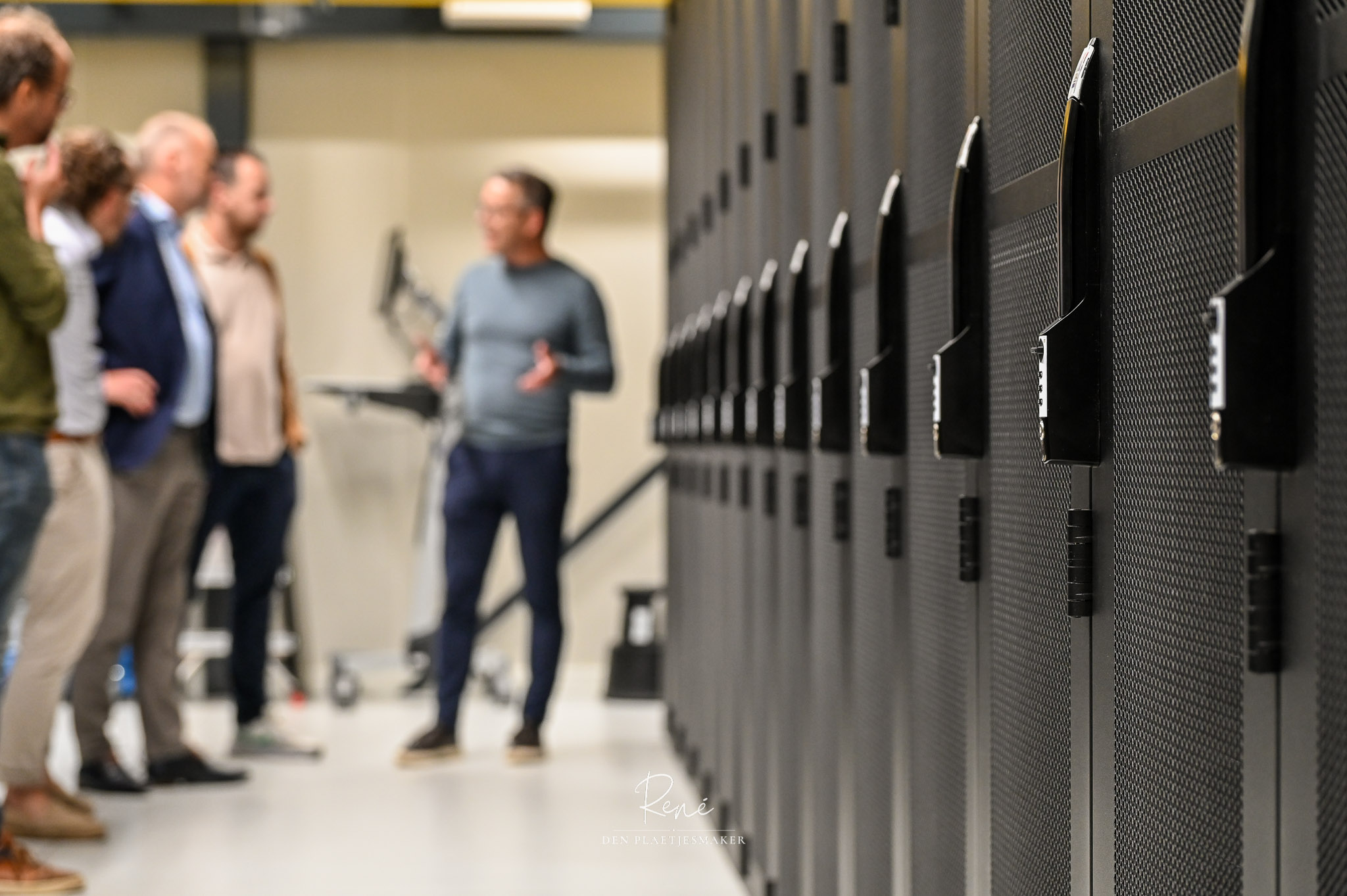 Mensen bekijken serverracks tijdens een rondleiding door een datacenter