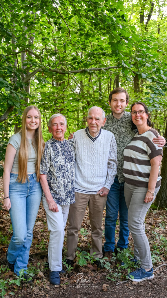 Familie van vier generaties samen tijdens een fotoshoot in het bos